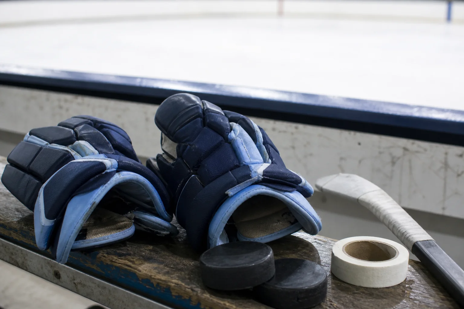 Hockey gloves on a rink bench for a custom team equipment guide
